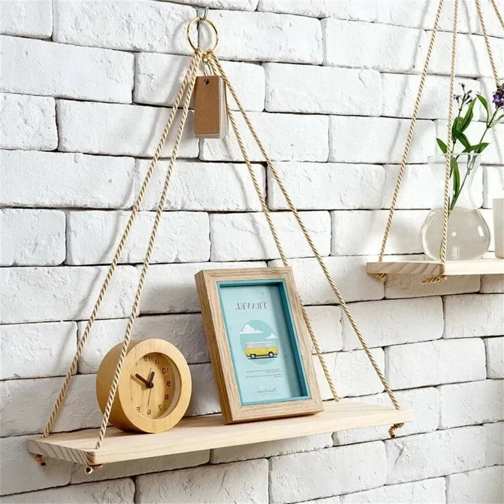 Natural pine swing shelf on a white brick wall holding a clock and picture frame