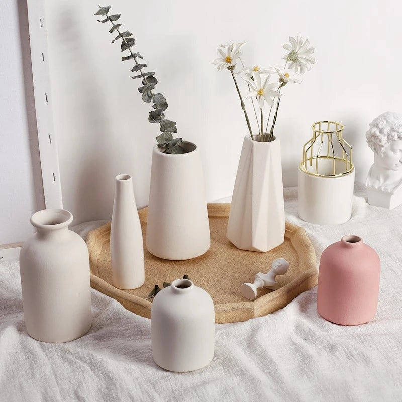Three matte white ceramic vases on a tray