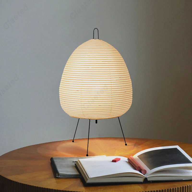 Lamp on a round wooden table beside an open book