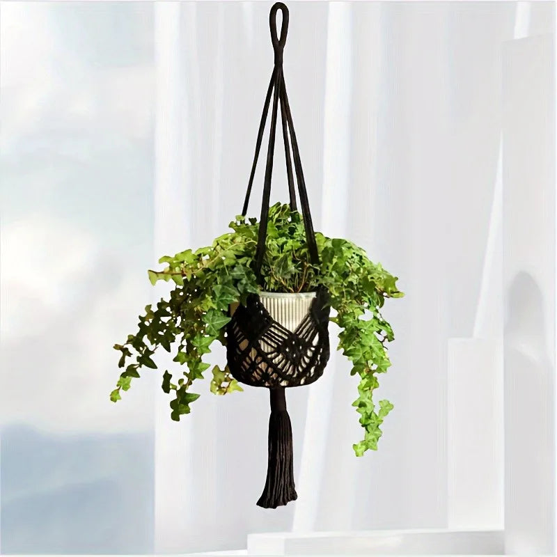 Black macrame plant hanger against a white curtain
