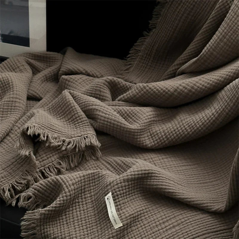 Folded cocoa waffle cotton throw showing drape and fringe