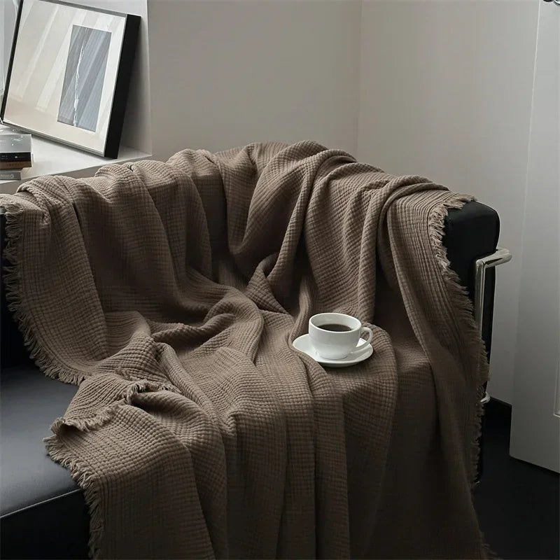 Brown cotton throw hanging over the back of a chair in a bright room