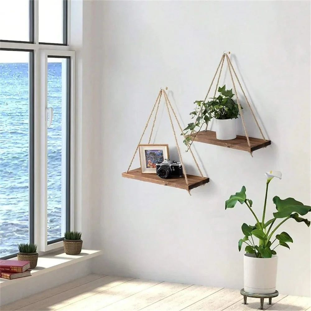 Hanging rope shelves beside a bright window with plants