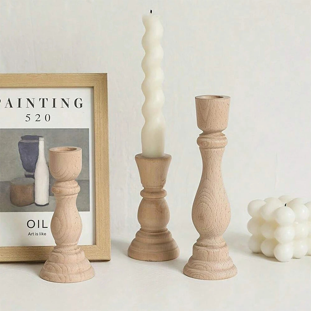 Two turned wood candlesticks beside a framed print