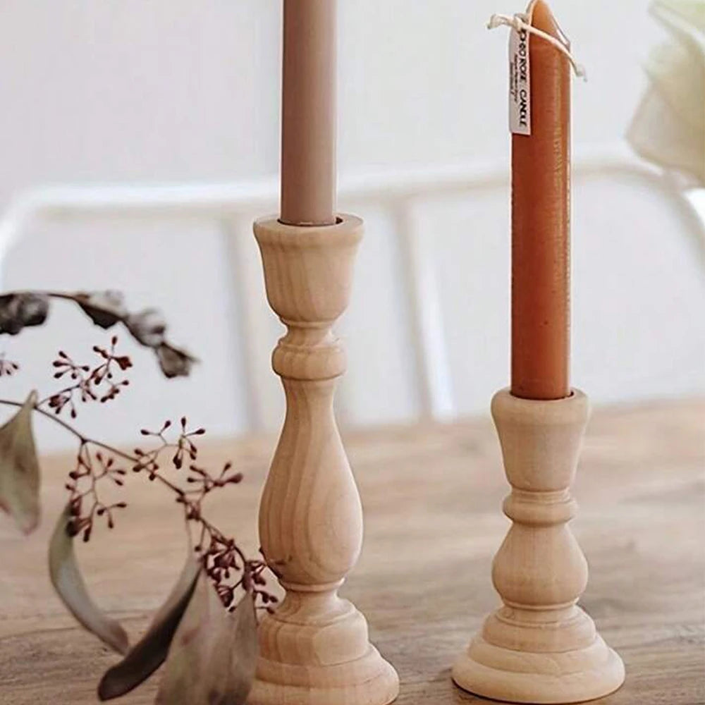 Taper candles in two wood candlesticks on a table